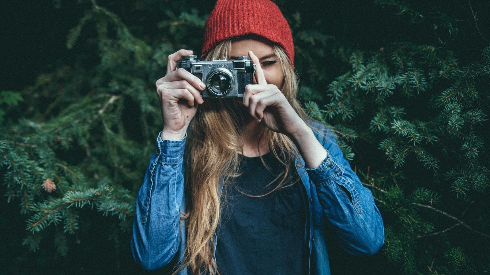 Meşədə fotoaparatla şəkil çəkən qadın